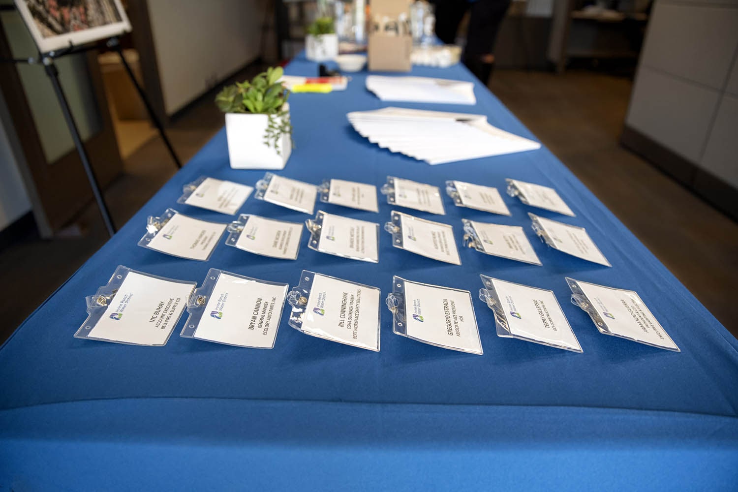 Registration desk with plastic name badges spread on a blue tablecloth.