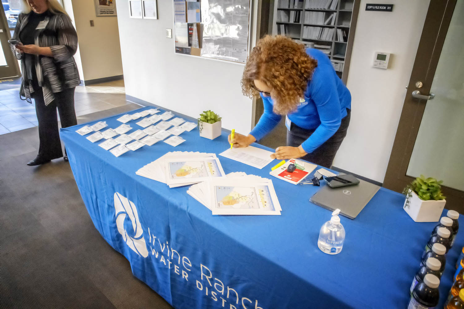 Registration desk at a water district event with a staff member filling out forms.