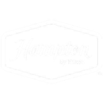 Hampton by Hilton logo inside a white hexagonal border on a green background.