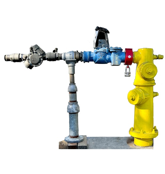 Industrial pipe manifold with yellow main valve and blue control valves on a metal stand