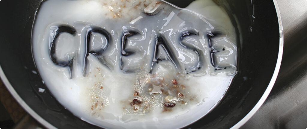 In a pan, fat forms the word GREASE on the surface.