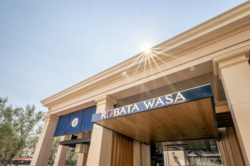 Entrance to Robata Wasa restaurant with sunburst above the canopy and a blue banner.